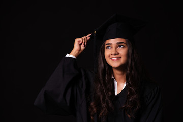 Junge Frau feiert den Abschluss ihrer Ausbildung, Portrait vor schwarzem Hintergrund mit  copy...