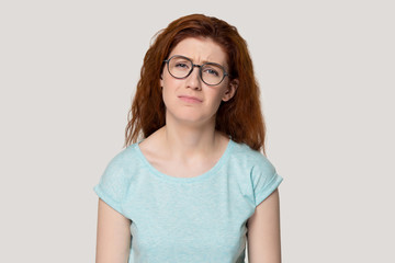 Fototapeta premium Unhappy upset face expressions redhead woman isolated on grey background