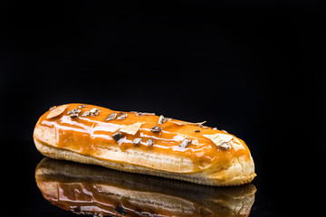 French Artisan Eclair on Black Reflective Background,Copy Space