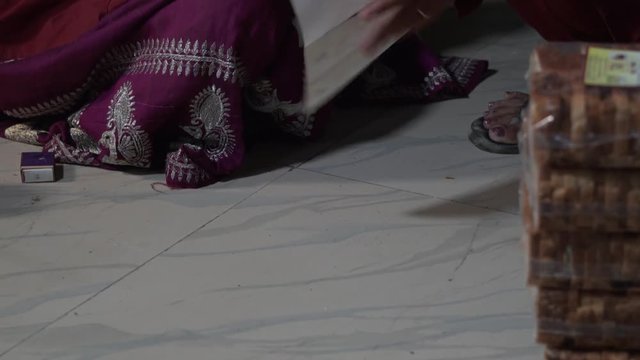 Hands putting product label on product with toasted bread, on the floor, rural India