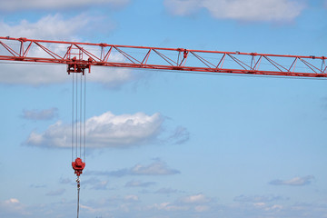 Close-up arrow of a construction crane on a background of blue sky, selective focus