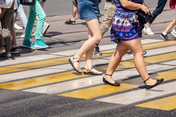 feet of pedestrians walking on the crosswalk