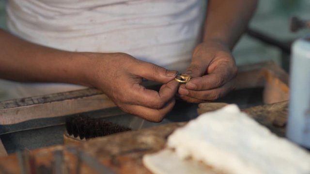 Macro: Jeweler forms the gold ring with pliers in jewelery