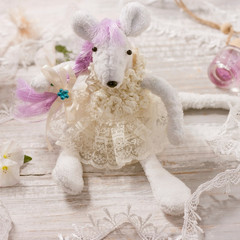 Charming white rat in a dress on a table with lace and flowers. Custom made toy, handmade, creative, do it yourself. Symbol 2020 on the eastern calendar. Close up