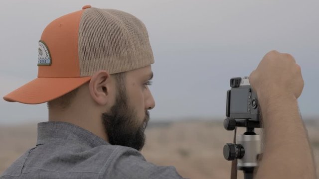 Photographer setting up camera for sunset picture in nature