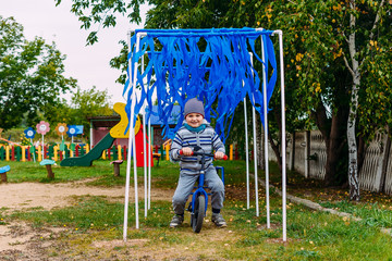 cheerful five-year-old boy riding a children's running bike