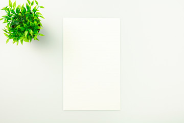 sheet of paper on white desk background with copy space. - top view.