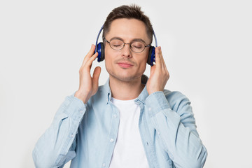 Headshot portrait man wearing headphones closed eyes enjoy favourite music