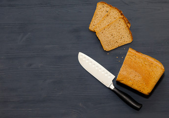 Freshly baked bread on a cutting Board. Black wooden background.