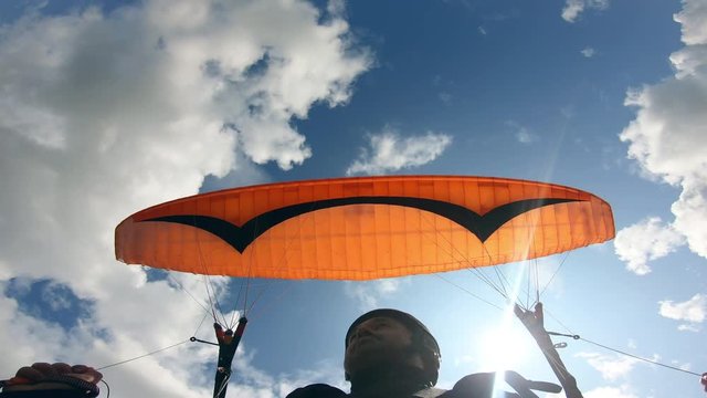 Parasailing process of a the man with parawing. Paraglider flying.