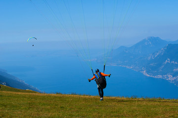 Paraglider flying over the Garda Lake (Lago di Garda or Lago Benaco). Paragliding on Monte Baldo....