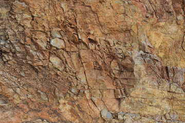 Natural old cracked brown stone wall surfage, texture close up.