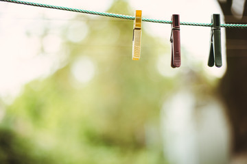 Close up clothes pin on a green background. Plastic clothes pegs on green rope. 