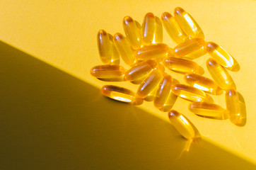 Fish oil capsules on a yellow background. Omega 3, omega 6, omega 9. Top view, copy space.