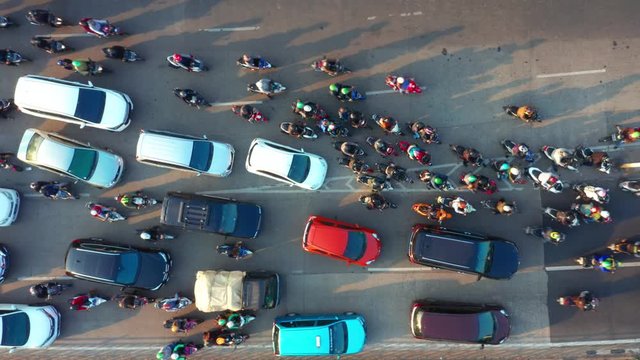 JAKARTA, Indonesia - July 30, 2019: Top down view of crowded motorcycle and cars moving on the road at rush hour in Jakarta downtown. Shot in 4k resolution