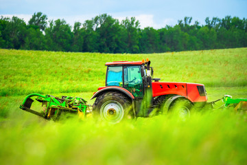 Agriculture. Red tractor green field.