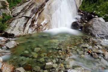 Fototapeta na wymiar A waterfall in the Italian Alps near the town of Macugnaga - July 2019.