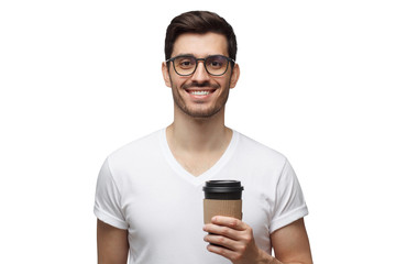 Young smiling man holding takeaway coffee, wearing glasses, enjoying hot drink, isolated on white