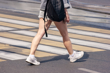 people crossing the street at pedestrian crossing on sunny