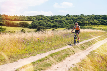 Obraz premium beautiful athletic young woman doing mountain bike