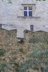 Fototapeta na wymiar Rhodes, Greece: A cannon protrudes from a wall in the 14th-century Palace of the Grand Master of the Knights of Rhodes.