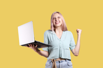 Young beautiful blonde woman with pink hair toner posing over bright colorful isolated background & holding white laptop. Portrait of teenage female model showing emotions. Close up, copy space.