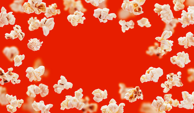 Popcorn frame, flying popcorn isolated on red background with copy space, movie poster concept