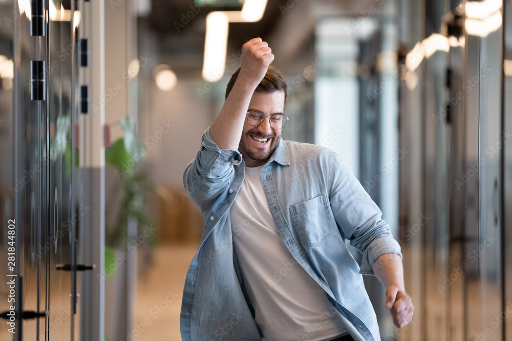 Sticker Ecstatic male winner dancing in office hallway laughing celebrating success