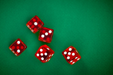 five rolling red dices on green background