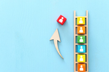 Business image of wooden ladder with people icons over blue table, human resources and management...