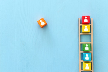 Business image of wooden ladder with people icons over blue table, human resources and management...