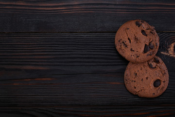 Obraz na płótnie Canvas Chocolate chip cookies on dark old wooden table with copy space