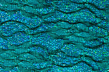 Abstract background of blue lace and sequins to look like the sea or fish scales