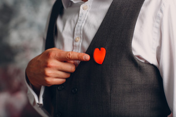 Portrait of a businessman шт vest with heart brooch. Business and success concept.