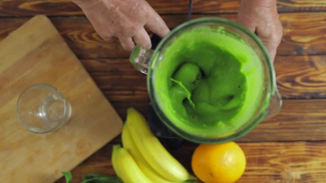 Senior man make green smoothie with spinach