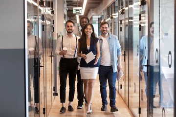 Happy multinational corporate business team stand in office hallway