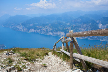 Fototapeta na wymiar Above view of the Lake Garda (Lago Di Grada or Lago Benaco) from Monte Baldo, Italy. Panorama of the gorgeous Garda lake surrounded by mountains. Selective focus