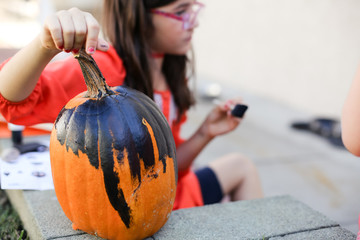 A family is decorating pumpkins during Halloween.