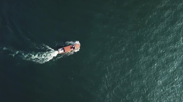 AERIAL footage of a newly married couple laying in a motorboat on Lake Como, Italy.