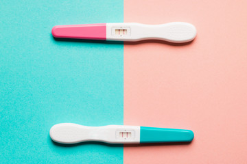 Positive pink and blue plastic pregnancy test on pink background