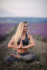 Fototapeta na wymiar Sporty woman practicing yoga. Woman on the lavender field. Healthy lifestyle concept.