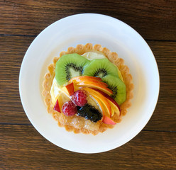 Delicious pastry cake with fresh fruit on table