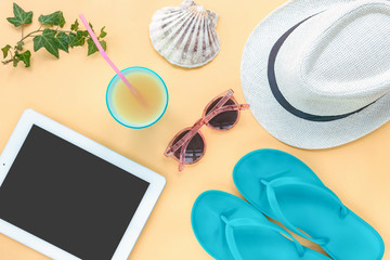 Tablet computer and travel accessories, summer flat lay, top view