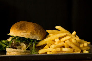 Hamburguesa de carne con papas con fondo negro