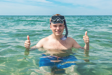 Funny man diver with snorkel equipment snorkeling mask and tube in ocean. Summer vacation swimming fun concept.