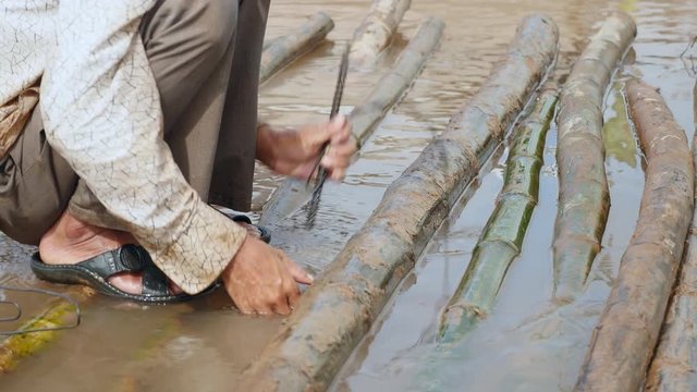 close up of wires twisted like cable ties to secure the bamboo poles together. Bamboo bridge during his construction