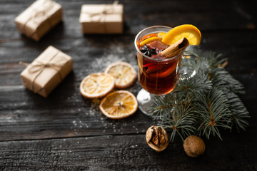 delicious and fragrant mulled wine is poured into a glass, a stick of cinnamon in wine, slices of...