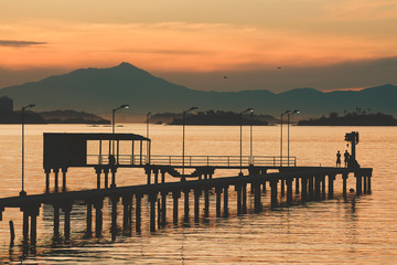 Kids playing on a pier at Guanabara Bay in the late afternoon