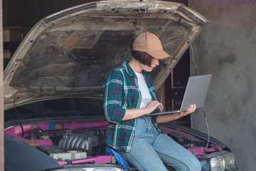 Female mechanic fixing car  in a garage