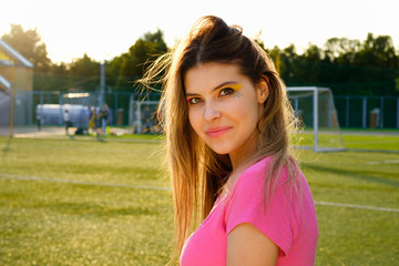 girl with bright creative make-up in the sunset at the playground